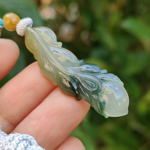 một bàn tay cầm một mặt dây chuyền ngọc bích