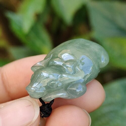 a hand holding a small green stone