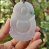Una mano sosteniendo un colgante de jade.