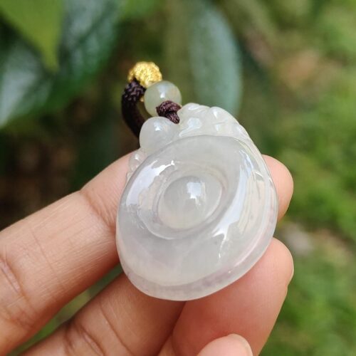 Una mano sosteniendo un colgante de jade.