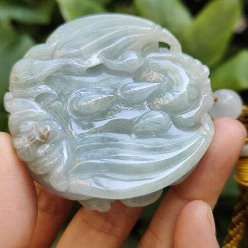 une main tenant un objet en jade