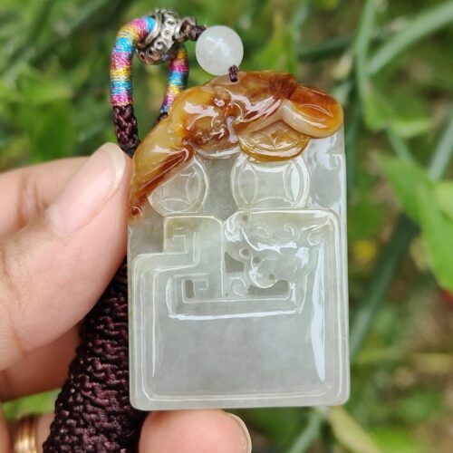 एक हाथ में जेड पेंडेंट थामे हुए