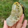 Una mano sosteniendo un colgante de jade.