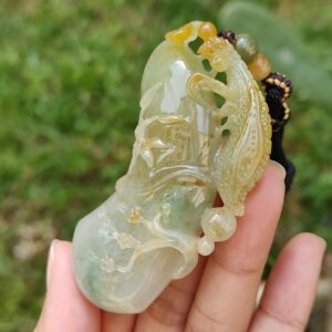 Una mano sosteniendo un colgante de jade.