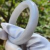 a hand in glove holding a white ring