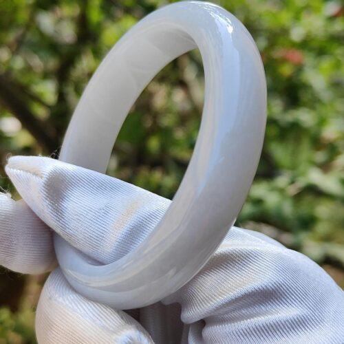 a hand in glove holding a white ring