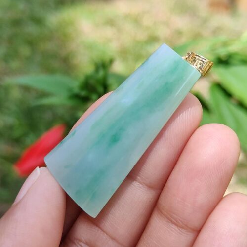 Una mano sosteniendo un colgante de jade.