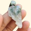 una persona sosteniendo un colgante de jade