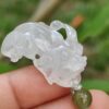Una mano sosteniendo un colgante de jade.