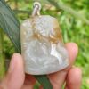 Una mano sosteniendo un colgante de jade.