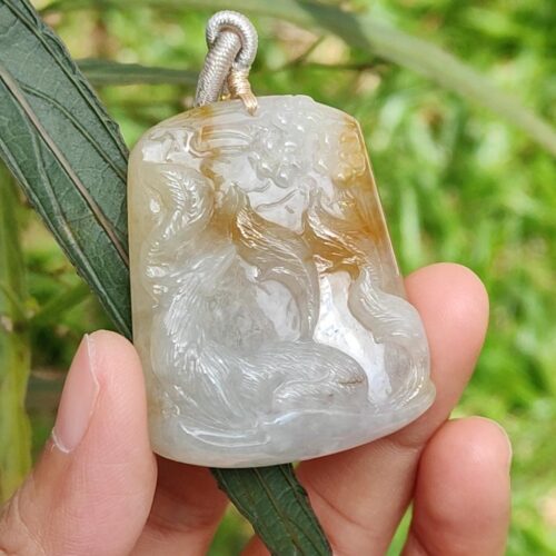 Una mano sosteniendo un colgante de jade.