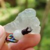 a hand holding a small white stone