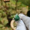 tangan yang memakai sarung tangan memegang cincin