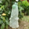 a hand holding a jade pendant