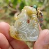 Una mano sosteniendo un colgante de jade.