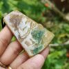 Una mano sosteniendo un colgante de piedra.