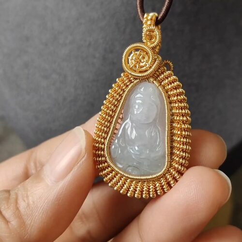 एक हाथ में सोने और सफेद पत्थर का पेंडेंट है