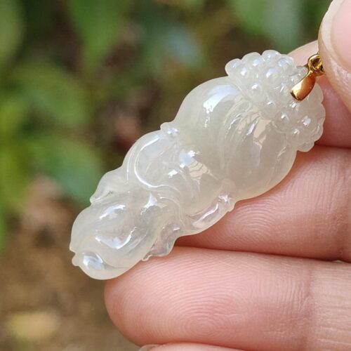 Una mano sosteniendo un colgante de jade.