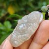 Una mano sosteniendo un colgante de jade.