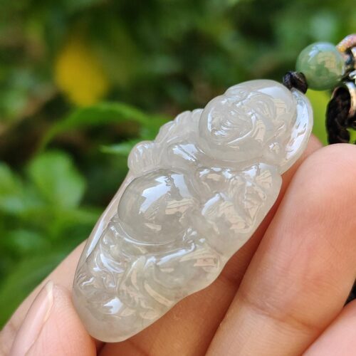 Una mano sosteniendo un colgante de jade.