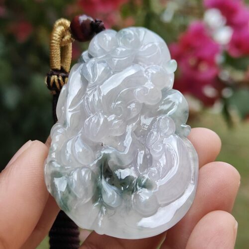 Una mano sosteniendo un colgante de jade.