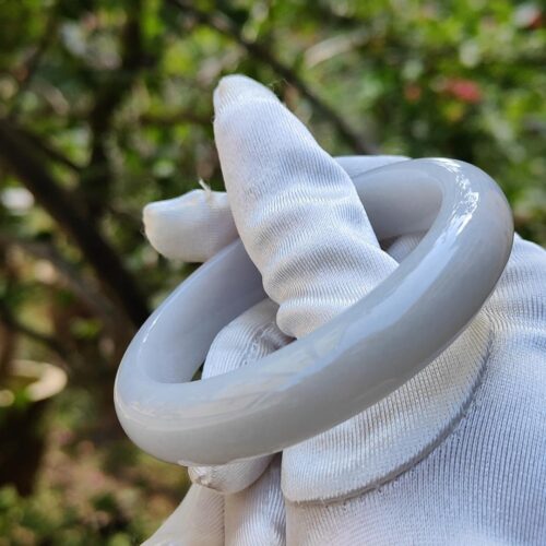 a hand in a glove holding a white object
