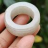 tangan memegang cincin putih