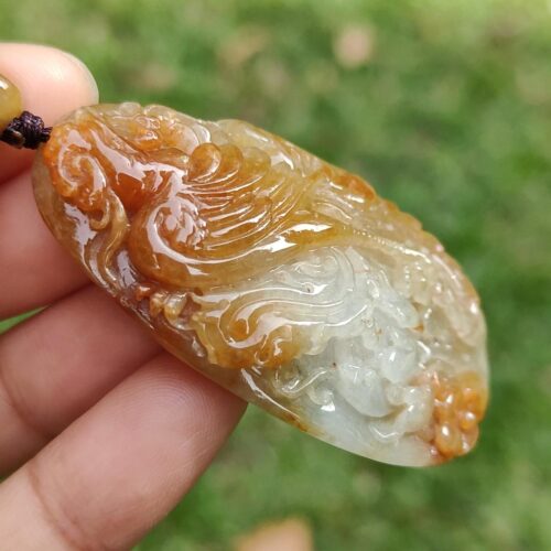 Una mano sosteniendo un colgante de jade.