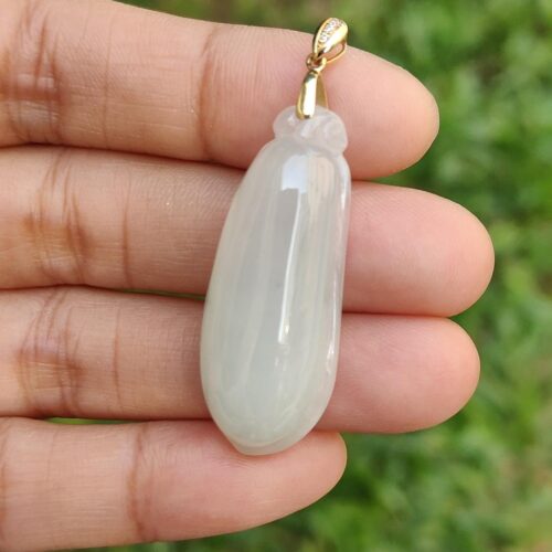 Una mano sosteniendo un colgante de jade blanco.