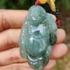 a hand holding a jade pendant