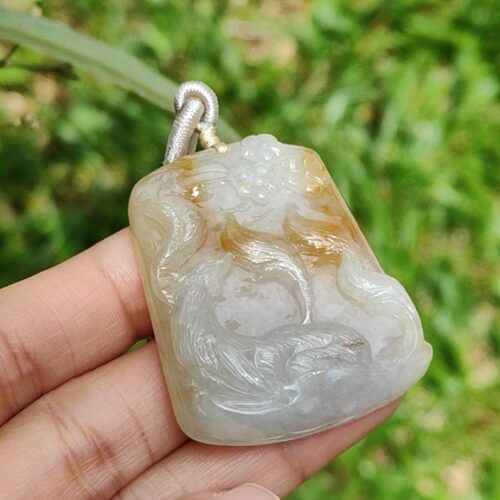 Una mano sosteniendo un colgante de jade.