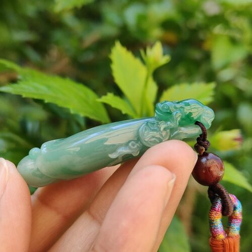 Una mano sosteniendo un colgante de jade.