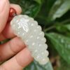 Una mano sosteniendo un objeto con forma de uva blanca.