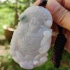 Una mano sosteniendo un colgante de jade.