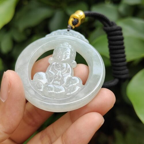 a hand holding a jade pendant
