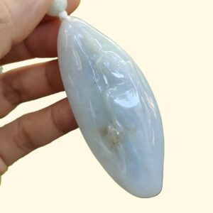 a hand holding a white stone pendant