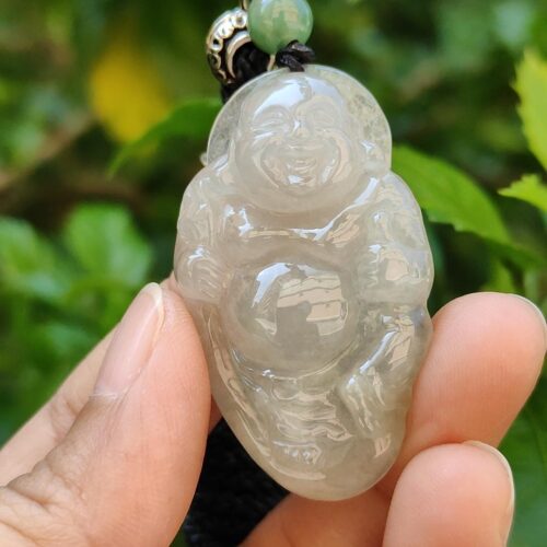Una mano sosteniendo un colgante de jade.