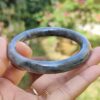 a hand holding a round stone ring