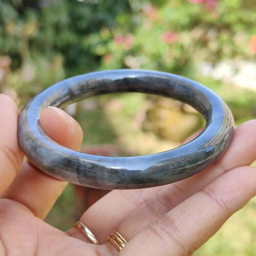a hand holding a round stone ring