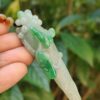 Una mano sosteniendo un colgante de jade.