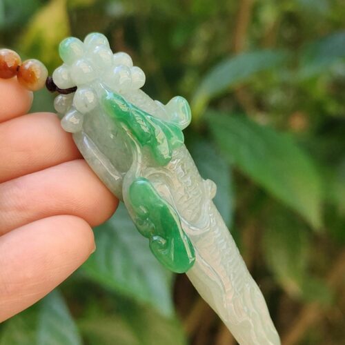 Una mano sosteniendo un colgante de jade.