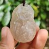 a hand holding a jade pendant