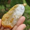Una mano sosteniendo un colgante de jade.
