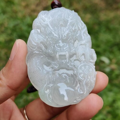 Una mano sosteniendo un colgante de jade.