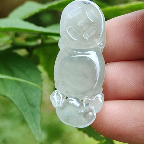 a hand holding a clear plastic snowman pendant