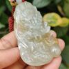 a hand holding a jade pendant