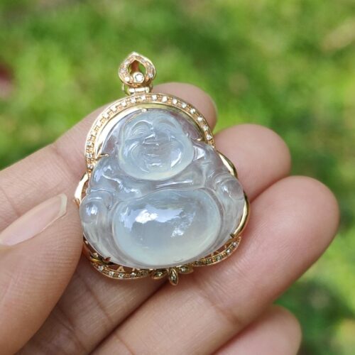 a hand holding a jade pendant