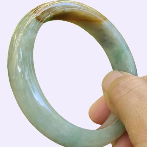 tangan memegang cincin giok