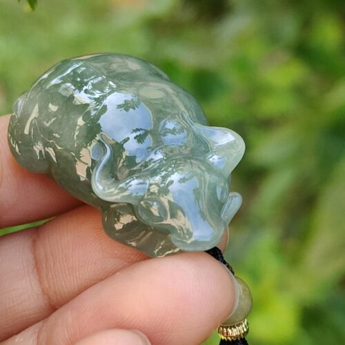 a hand holding a jade animal