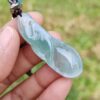 a hand holding a blue and green necklace